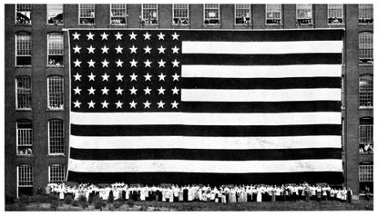 Workers beneath an American flag.