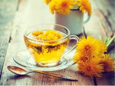 Dandelion Tea Next To Dandelion Flowers