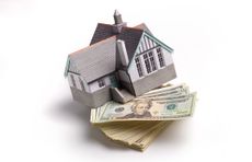 House on pile of money representing mortgage payment