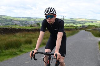 Image shows a cyclist wearing sunglasses.