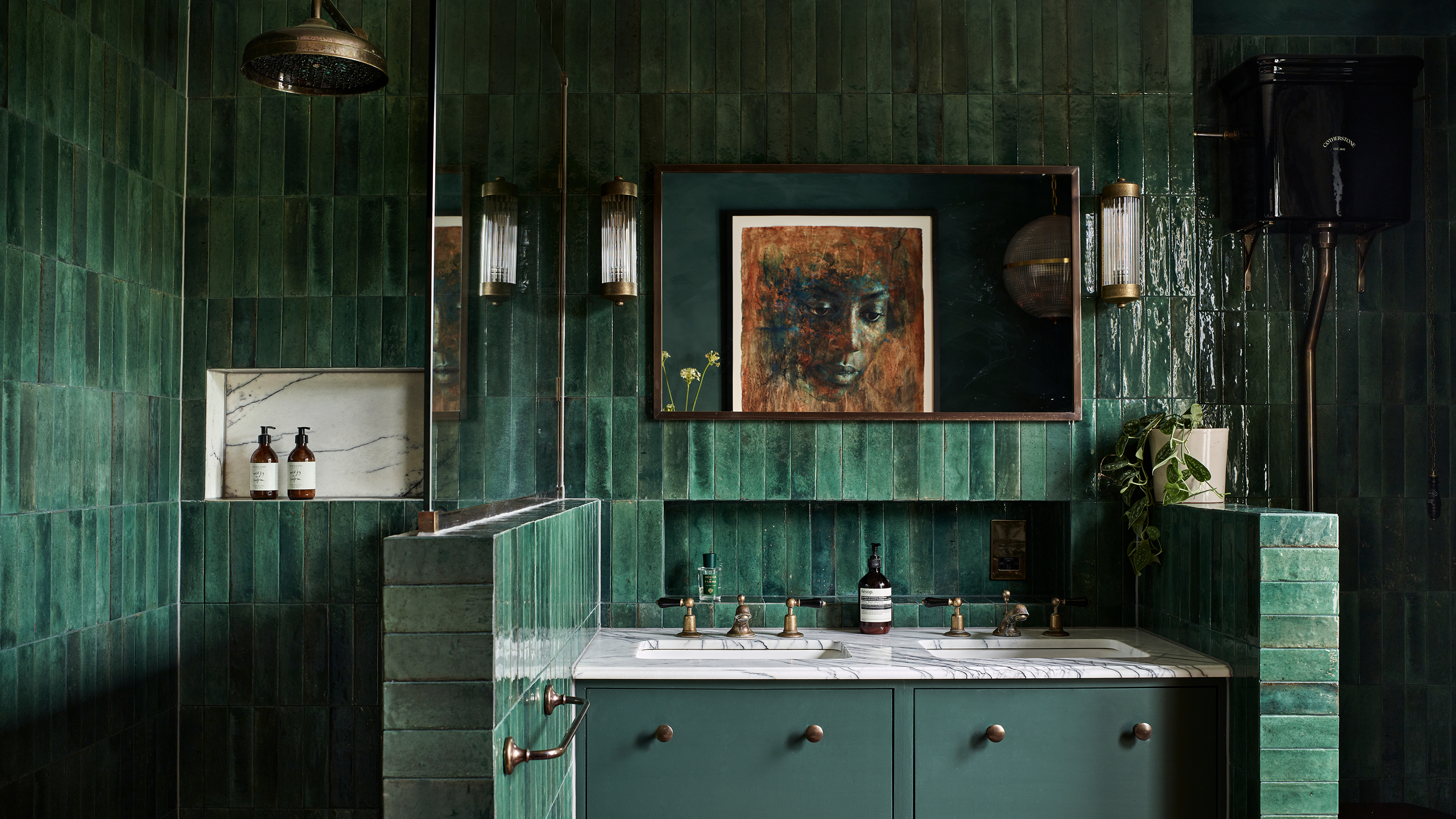 Luxury bathroom with dark green tiles, twin vanity unit, shower with brass shower head