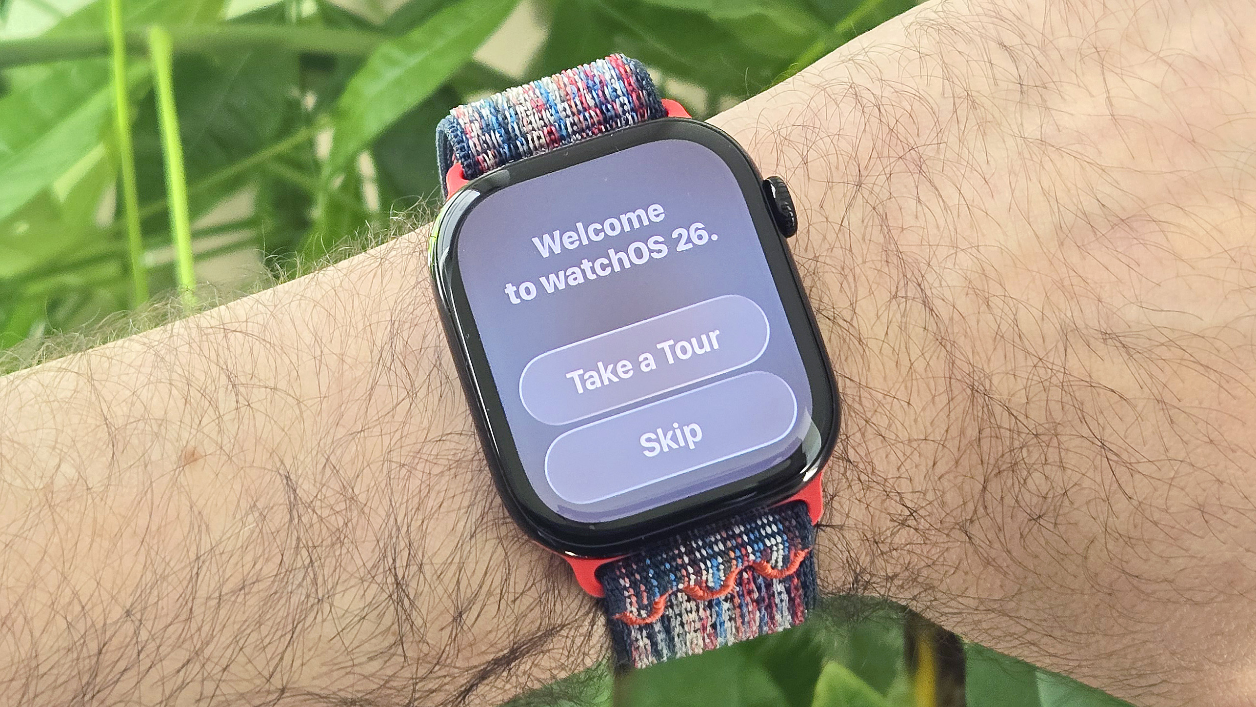 Close-up of an Apple Watch Series 10 on a user's wrist with a "Welcome to watchOS 26" message on display