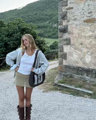 Woman wearing knit miniskirt and tall brown boots.