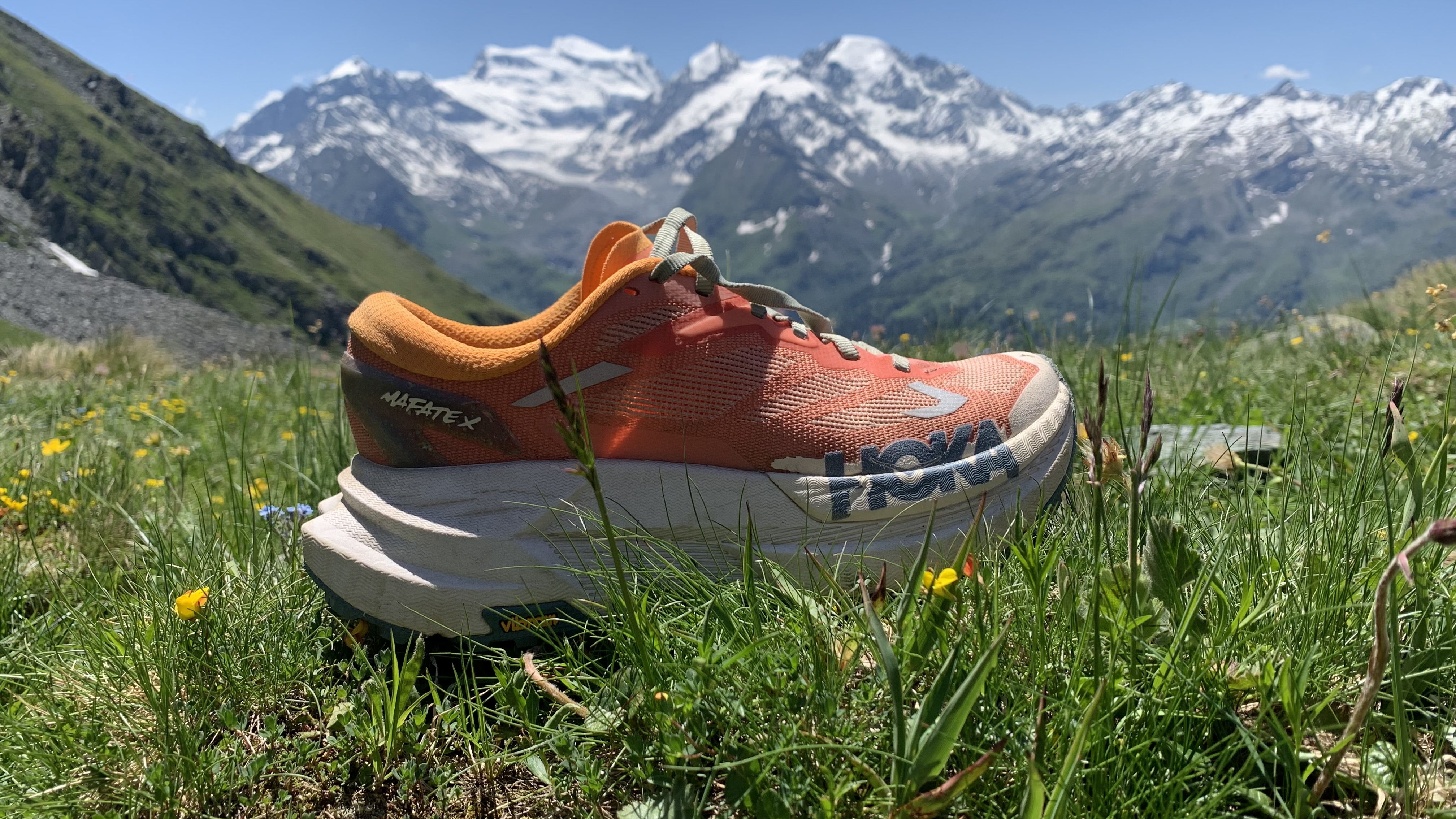 Hoka Mafate X trail running shoe with Swiss mountains in background