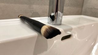 A makeup brush drying on a sink
