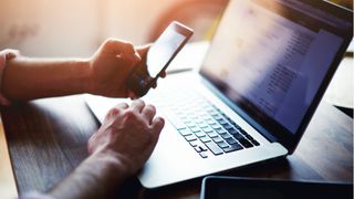 Man using laptop and smartphone