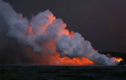 Lava enters the Pacific Ocean, causing a steam cloud.