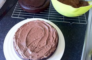 Covering a chocolate cola cake with buttercream