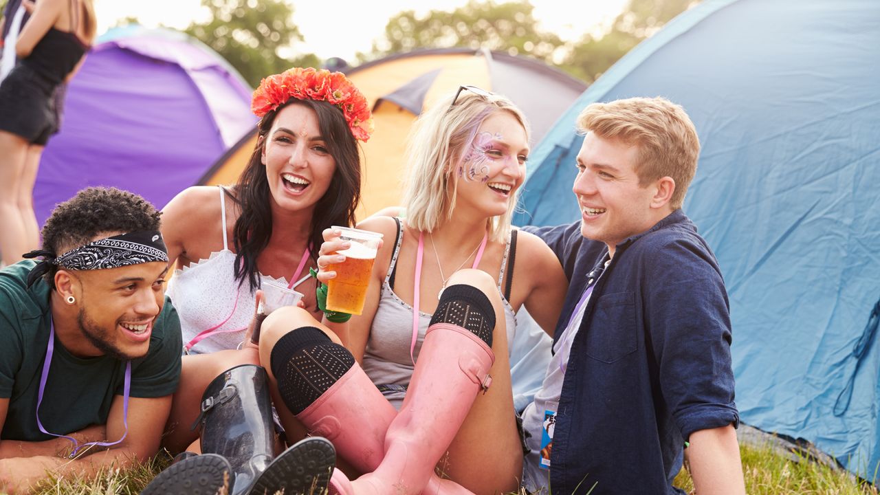 Festival camping: four friends hanging out at a campsite