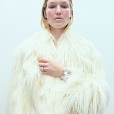 Model wearing a white faux fur jacket sold at Selfridges