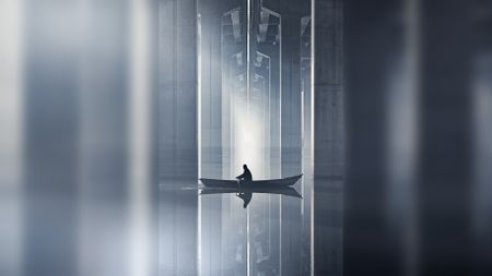A person rows a small boat through calm waters under a modern bridge, with towering concrete beams