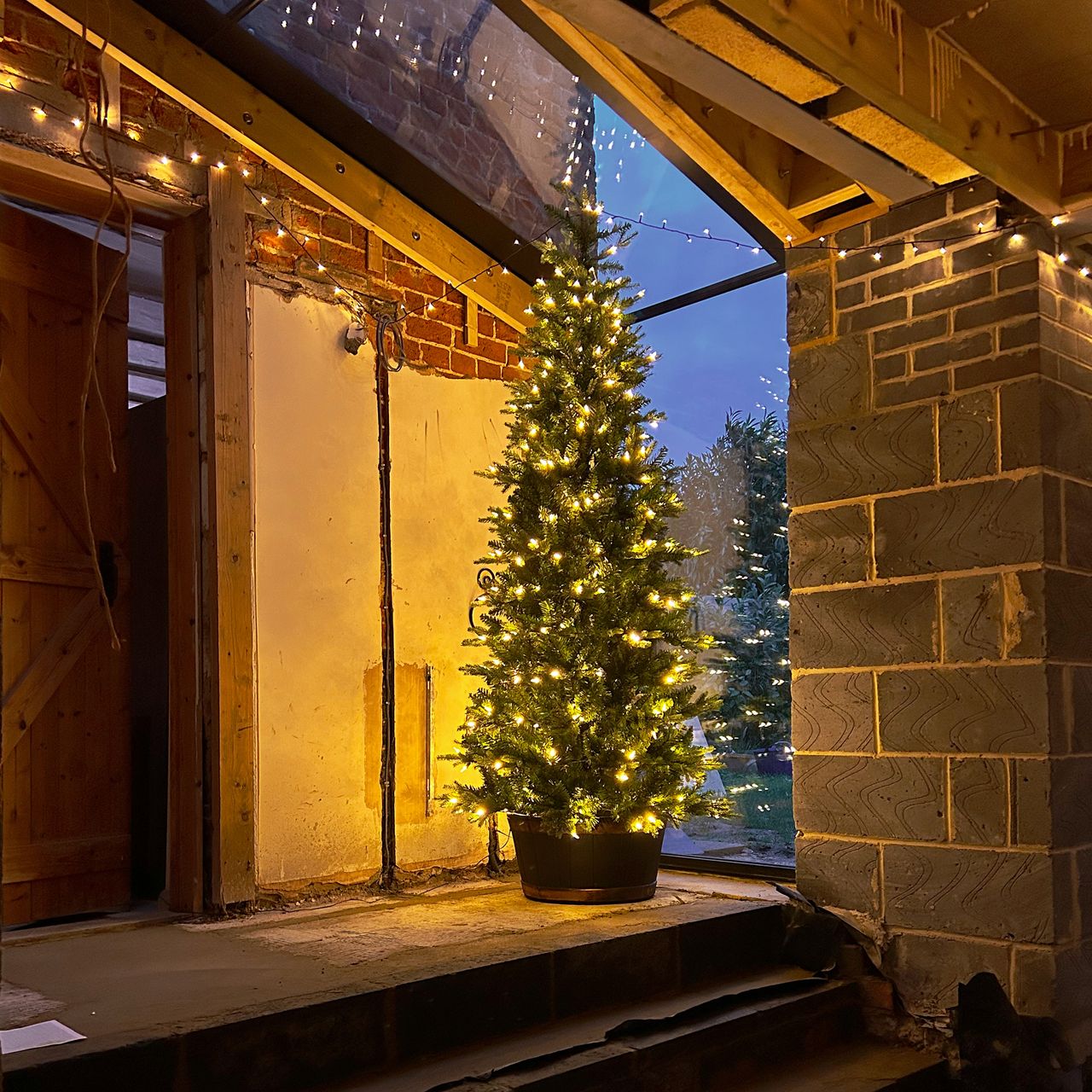lit christmas tree in a half-renovated extension