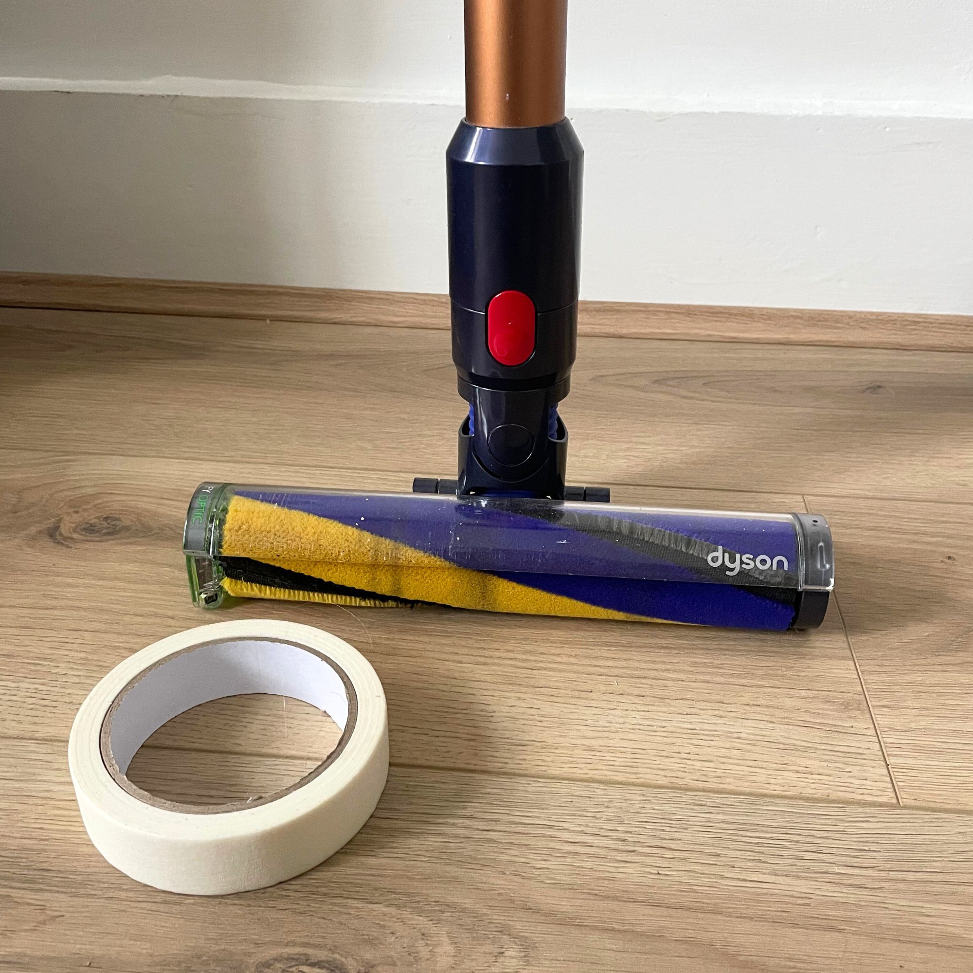 Dyson Gen5detect on wood-effect flooring, with a roll of white masking tape in front of it
