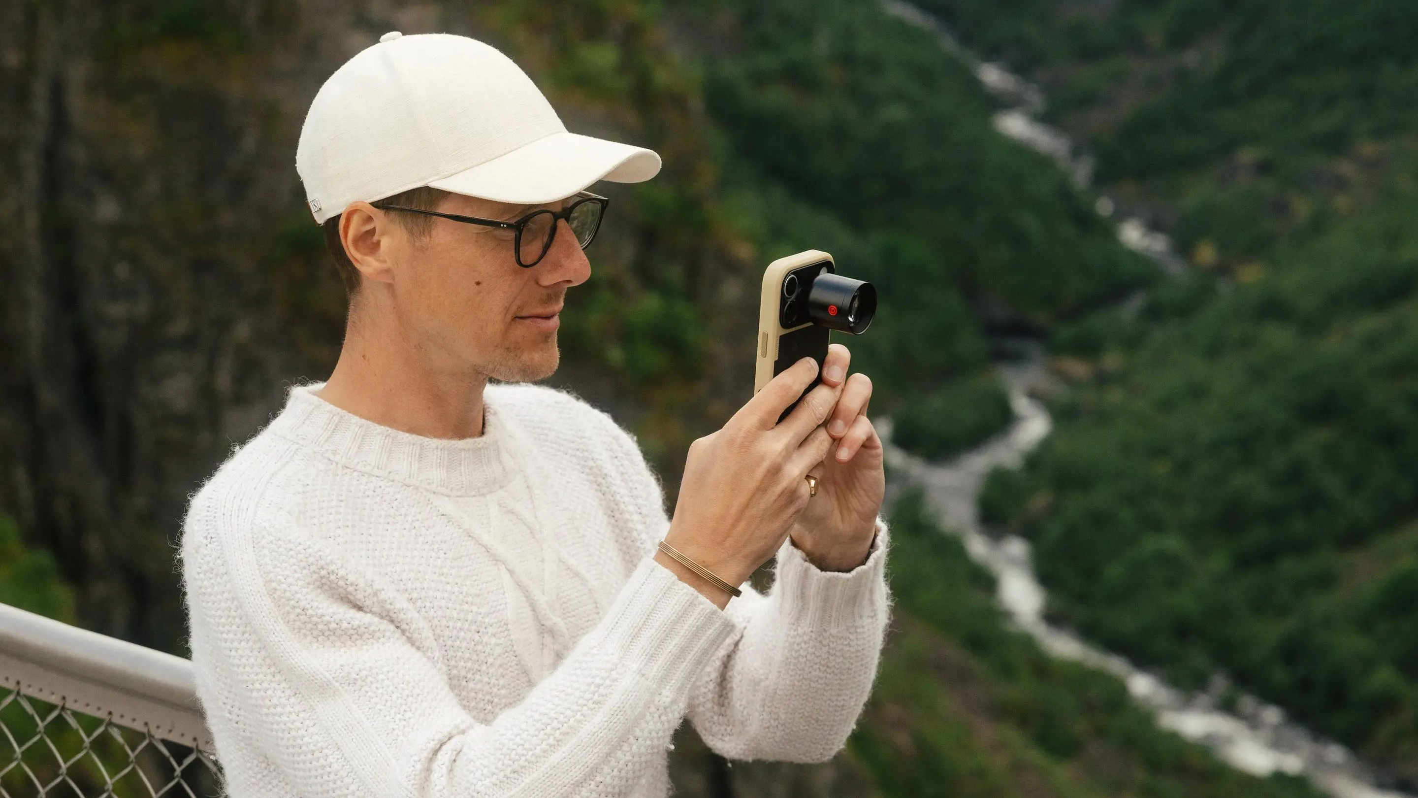 A person holds an iPhone with the Moment 240mm SuperTele lens