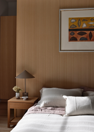 A bedroom with an attached floor-to-ceiling headboard