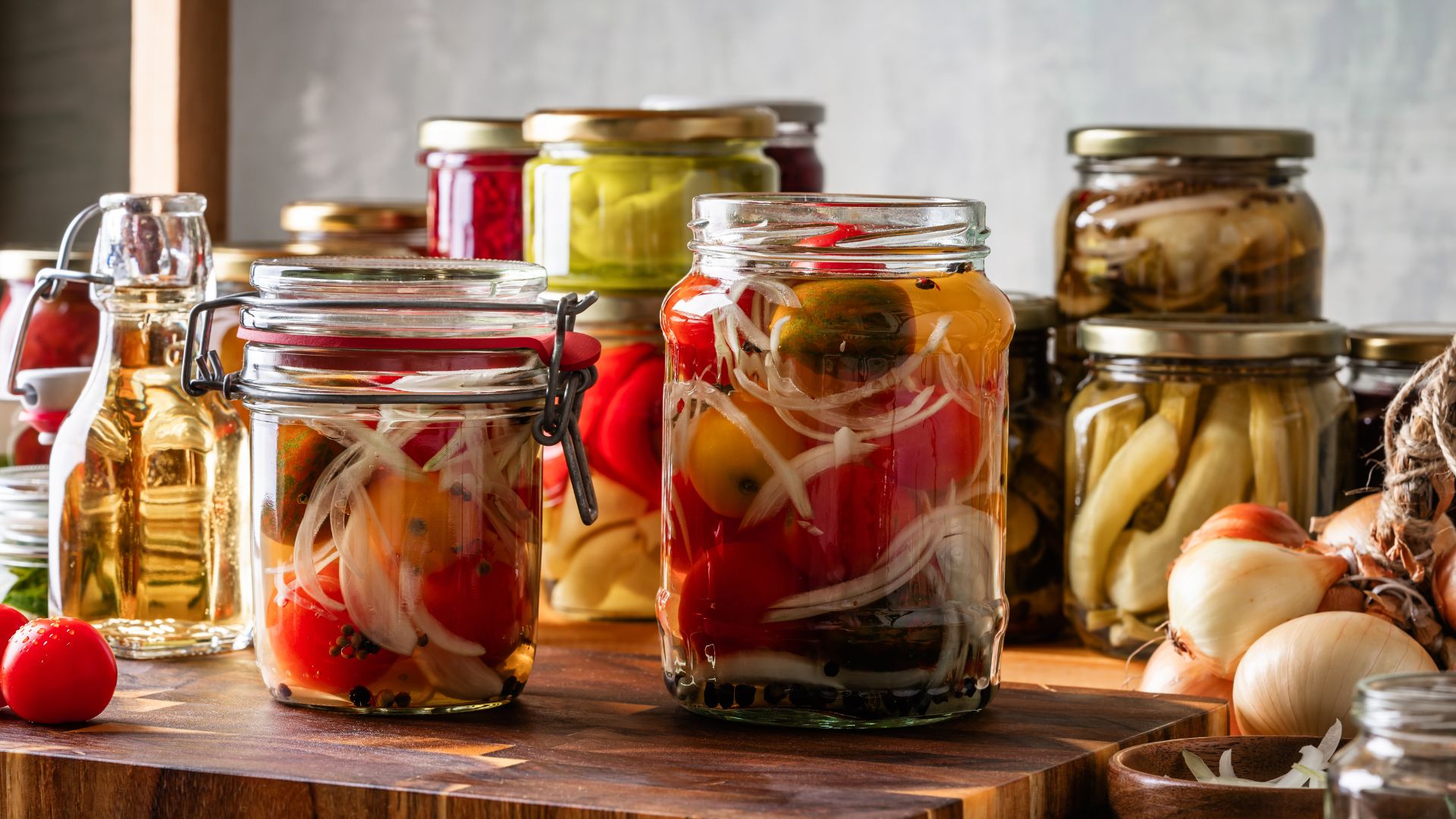 Pickled and fermented vegetables in jars sitting on wooden counter
