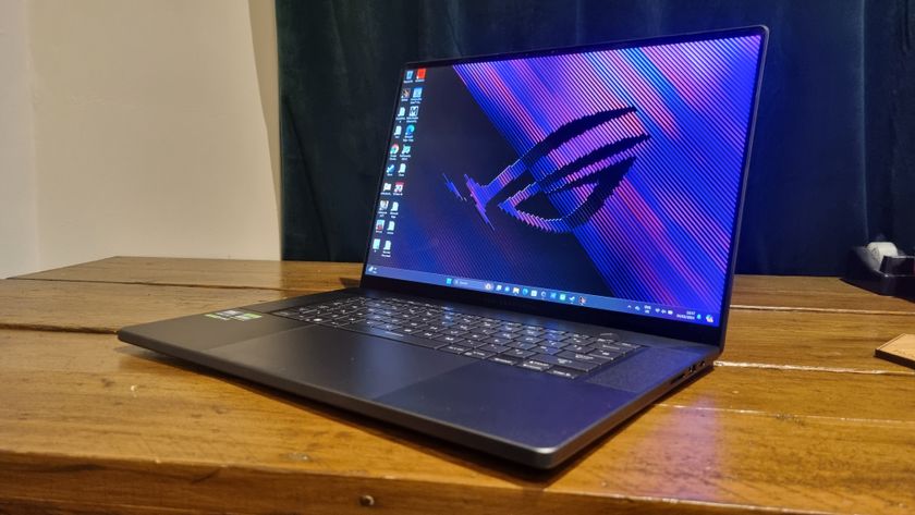 The Asus ROG Zephyrus G16 sitting at an angle on a wooden desk