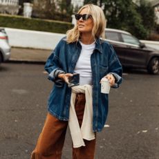 Lucy Williams wears brown jeans and a denim jacket