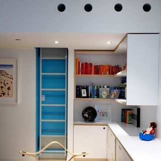 childrens play room with white wall and books cabinates
