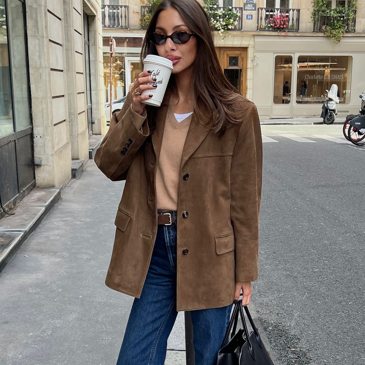 Woman in brown sweater, blazer, and jeans