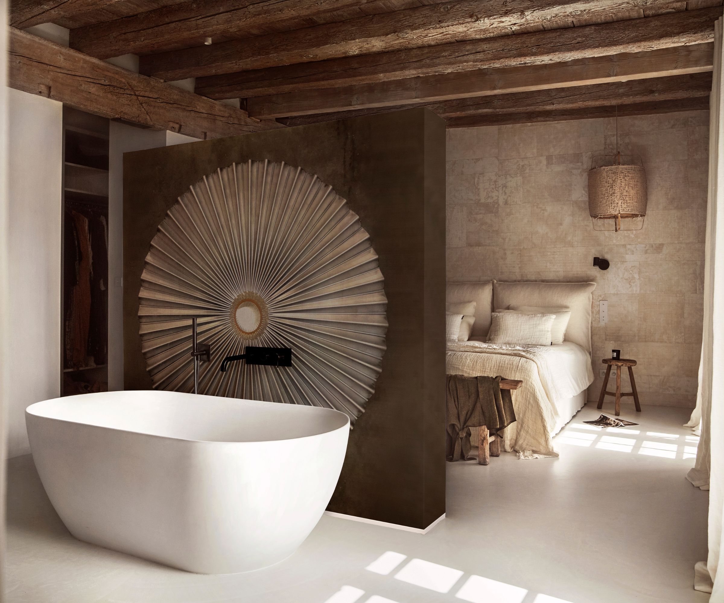 A Mediterranean bedroom with limewash walls and a freestanding tub behind a divider