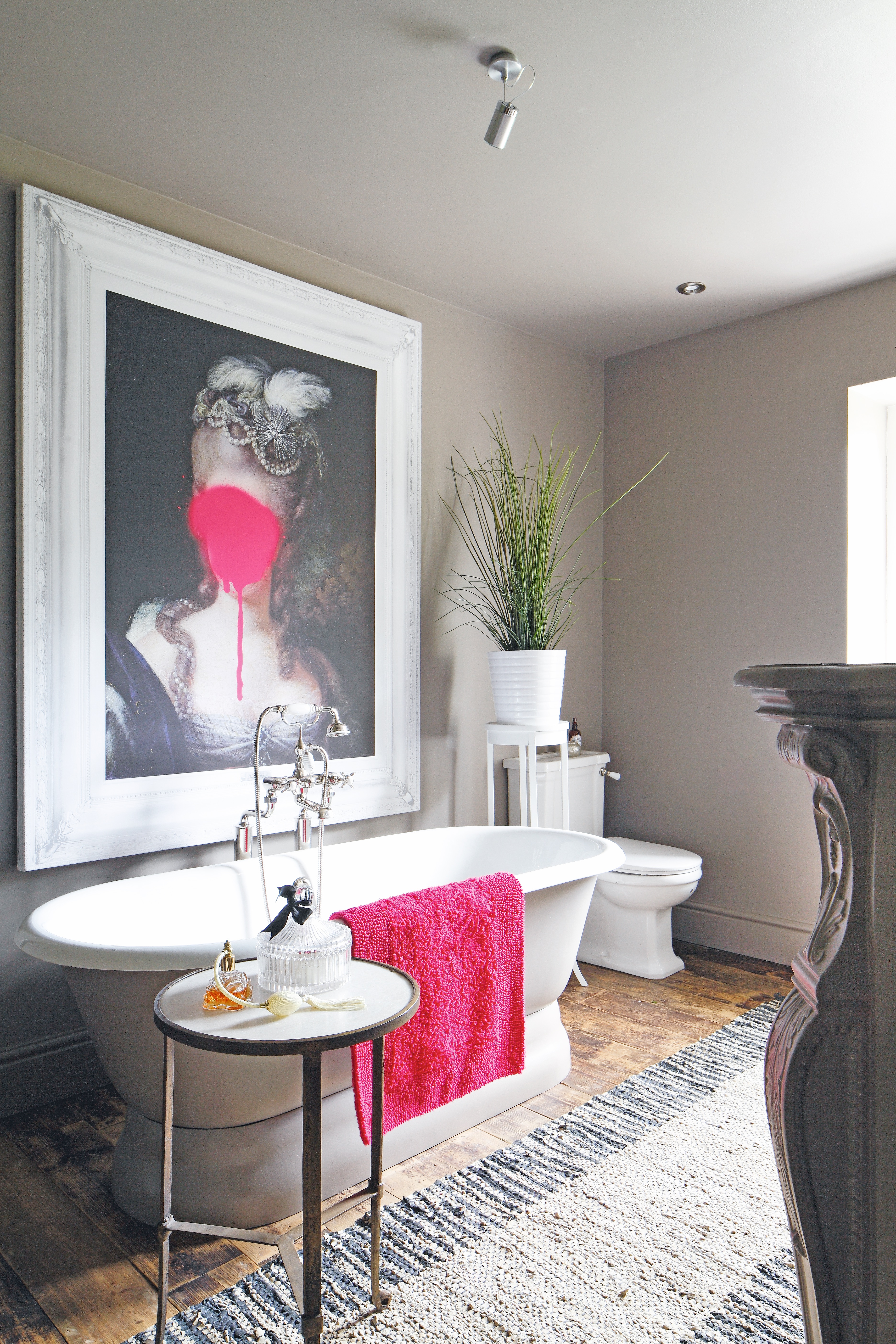 traditional style bathroom with white scheme, freestanding bath and large piece of artwork with modern twist