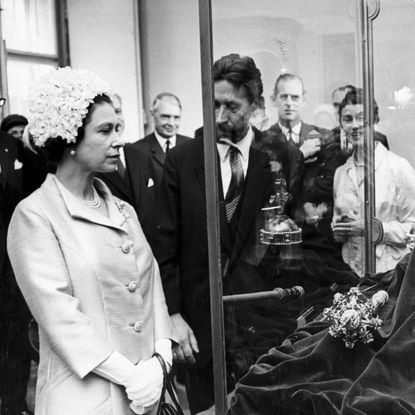 Queen Elizabeth looking at a crown inside a glass case
