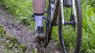 The S-Works Recon lace shoe being ridden through a muddy puddle