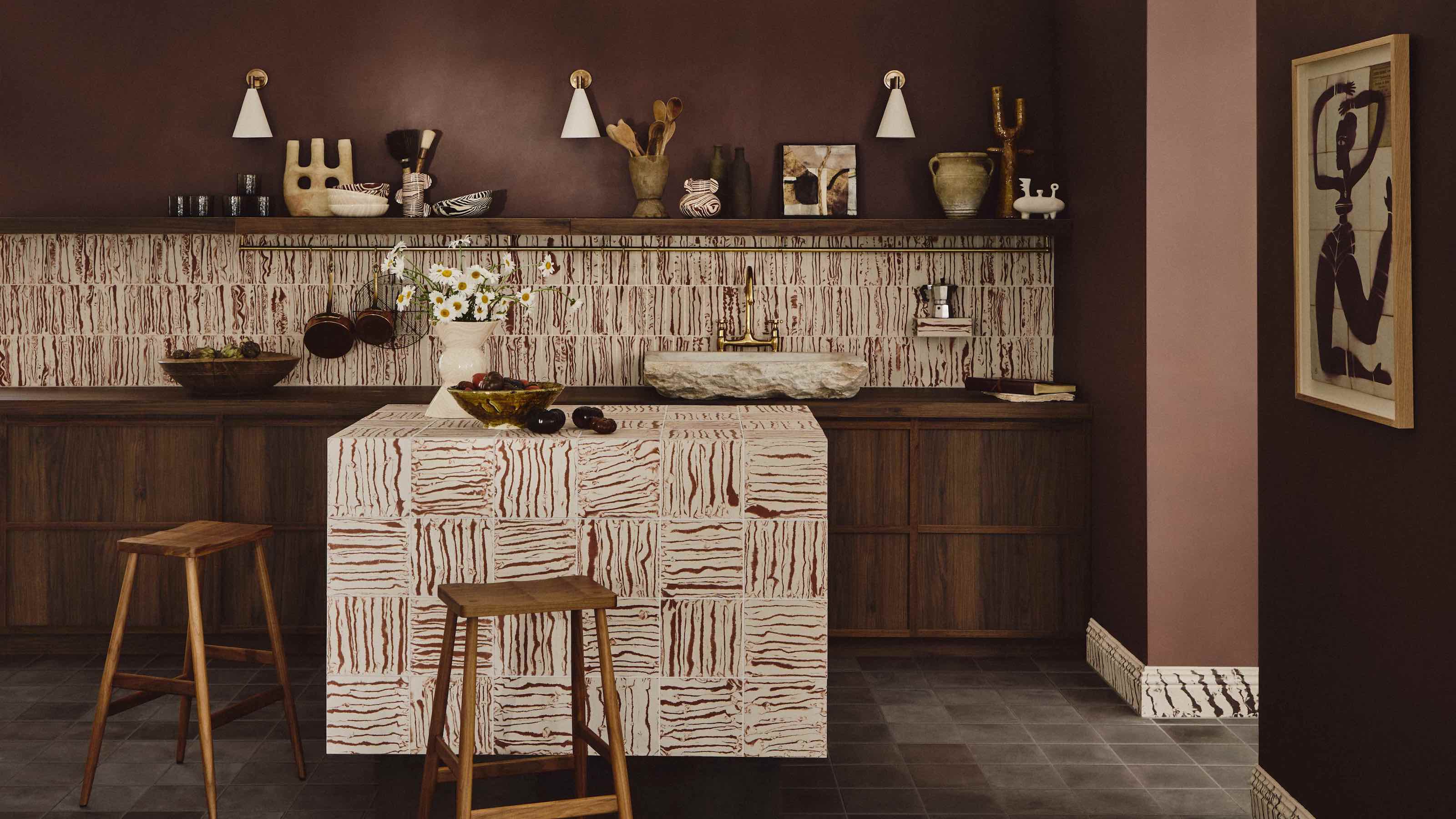 kitchen in brown with patterned tiled island and bar stools beside it as well as an open shelving unit above the countertops
