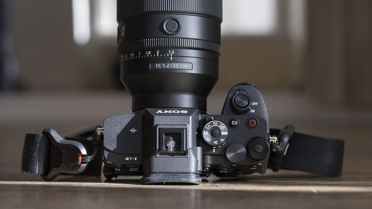 The Sony A7R V camera sitting on a wooden floor