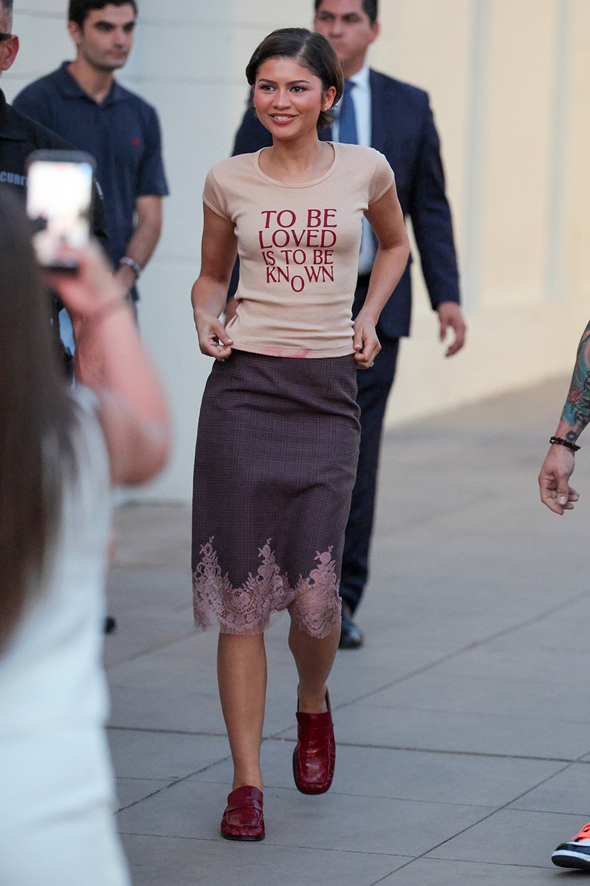 Zendaya wearing a The Drama T-shirt, lace-trim pencil skirt, and red loafers