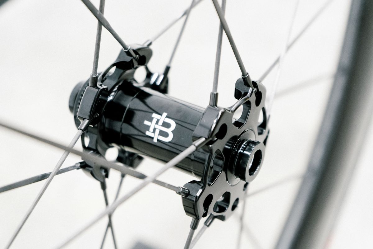 An aero road wheel stands against a white wall