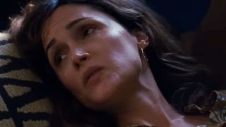 Rose Byrne in close up, looking to her right with her head on a pillow. 