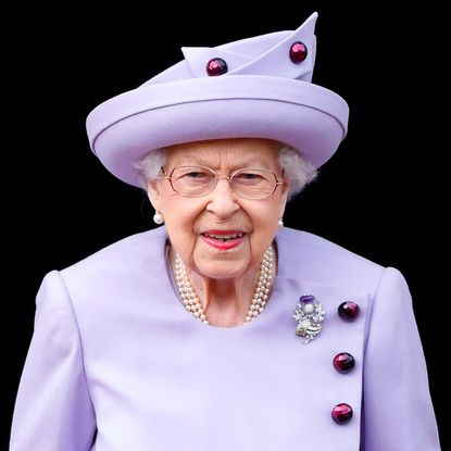 Queen Elizabeth wears a lilac dress and matching hat
