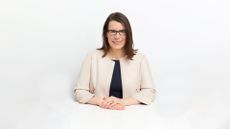 A half-shot of a woman, Cathy Polinski, in a white room