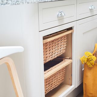 white kitchen cabinet with wood basket