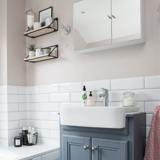 a grey vanity unit with white sink and chrome tap