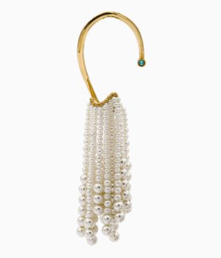 Woman's earring for unpierced ears. A gold hook with a string of different sized white pearls hanging from it.