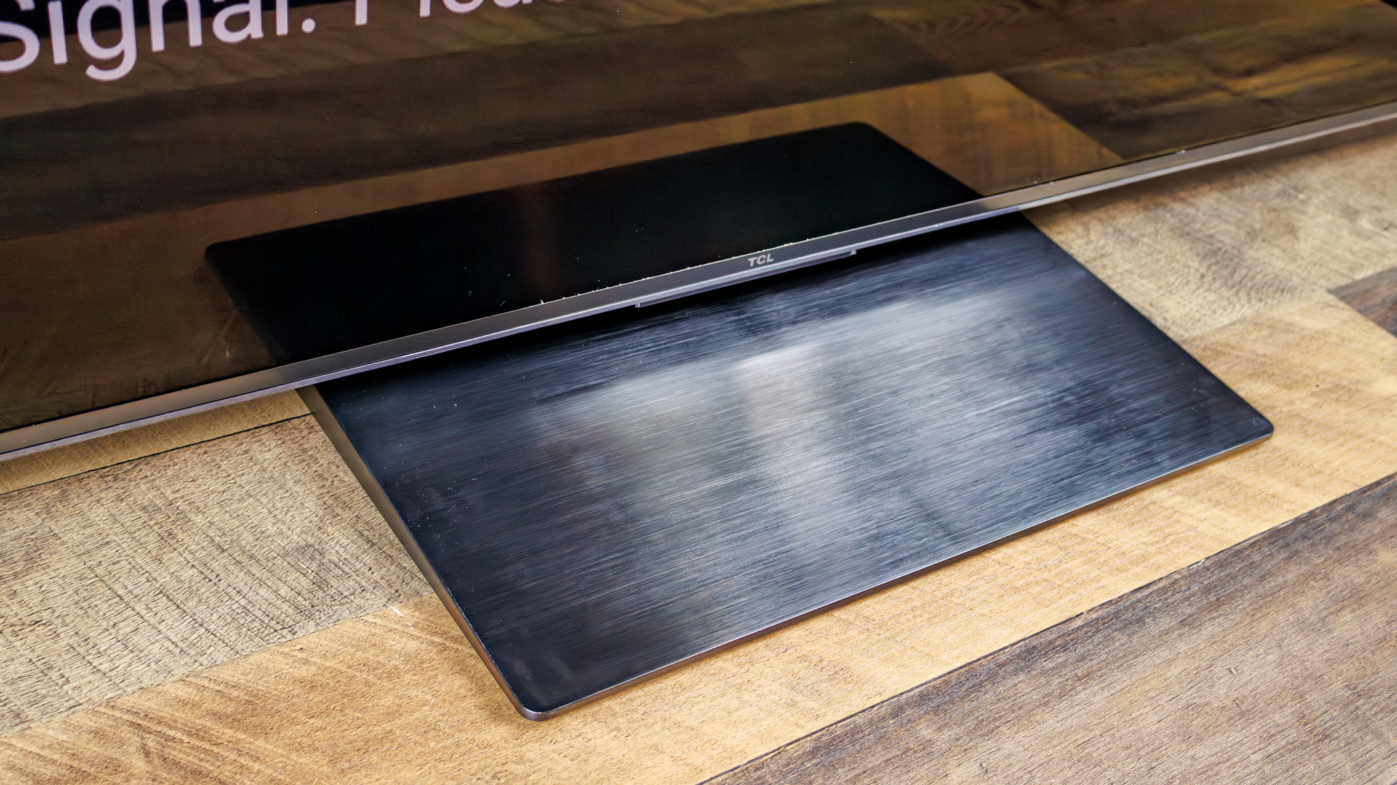 The pedestal stand of a TCL QM7L 75-inch TV