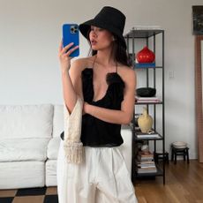 Influencer elevates her black and white outfit with Toteme's red kitten heel flip-flops.