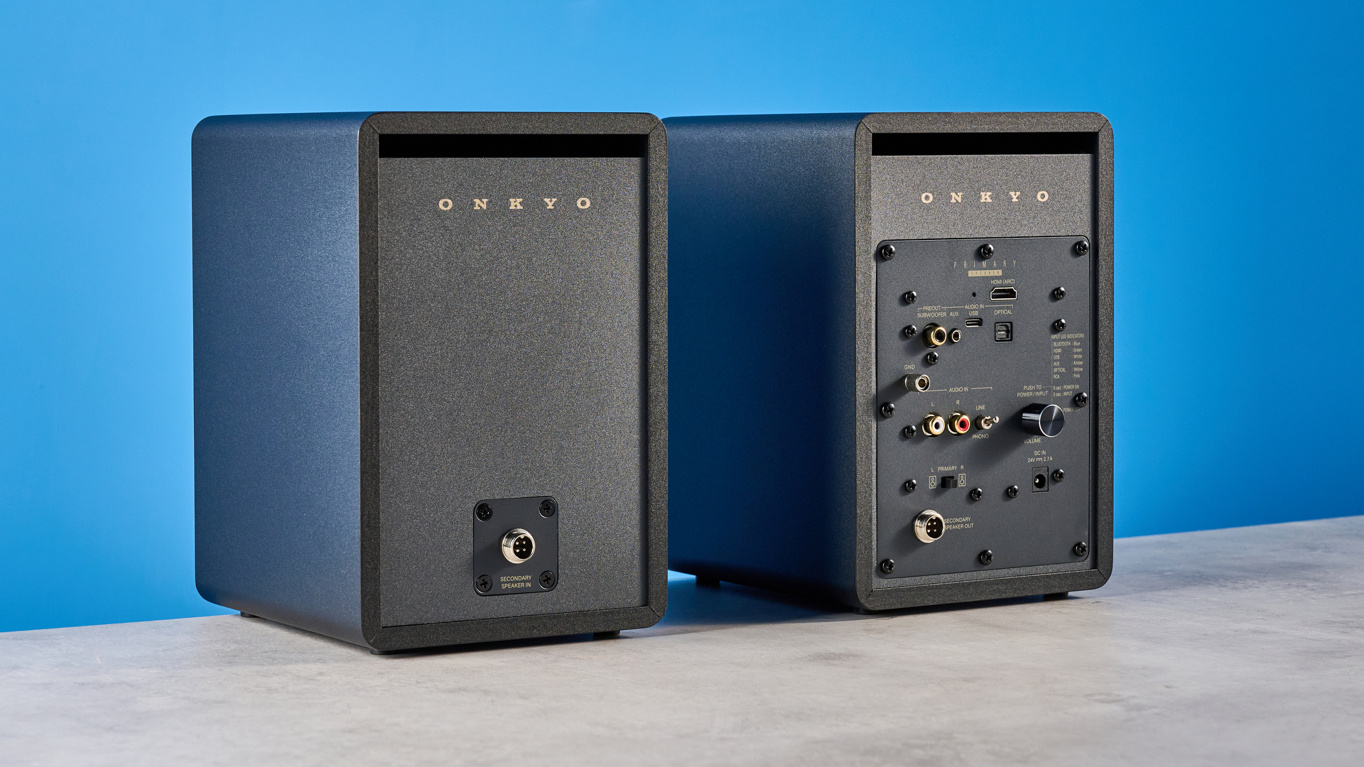 Onkyo GX-30ARC bookshelf speakers photographed on a blue background