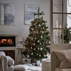 artificial christmas trees in a cosy living room