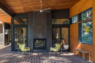 Cabin with indoor outdoor fireplace and green chairs