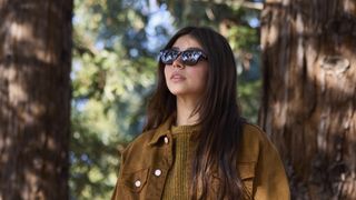 A woman in the woods wearing prototype smart glasses developed for Google's Android XR platform