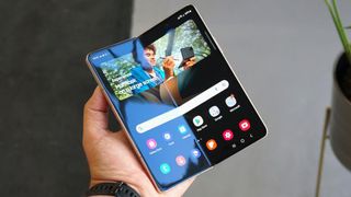 Ein Samsung Galaxy Z Fold 4 aufgeklappt in der Hand einer Person