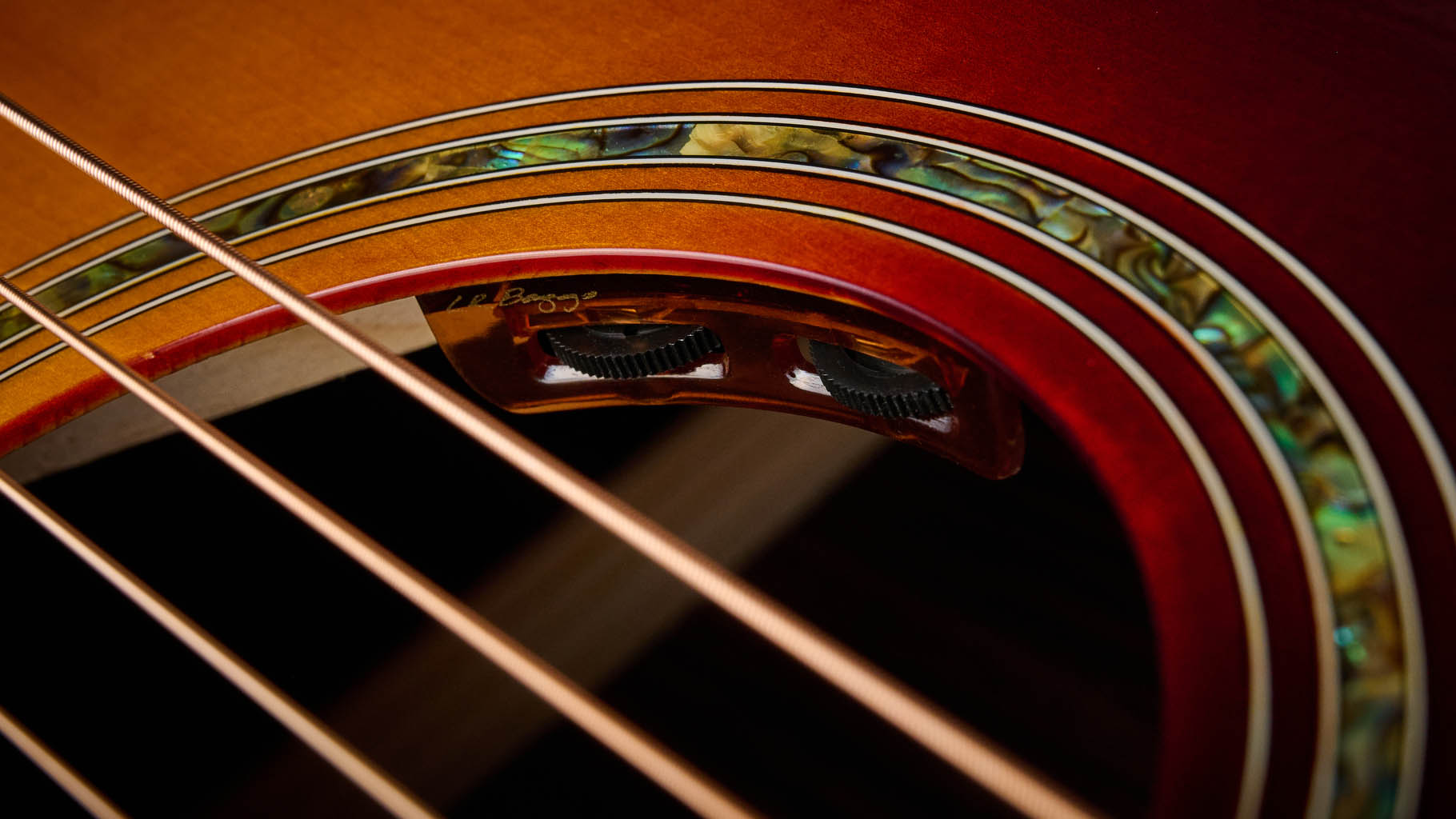 The Epiphone Inspired by Gibson Custom Hummingbird photographed in all its glory, in close-up and against a wheat-coloured rug.