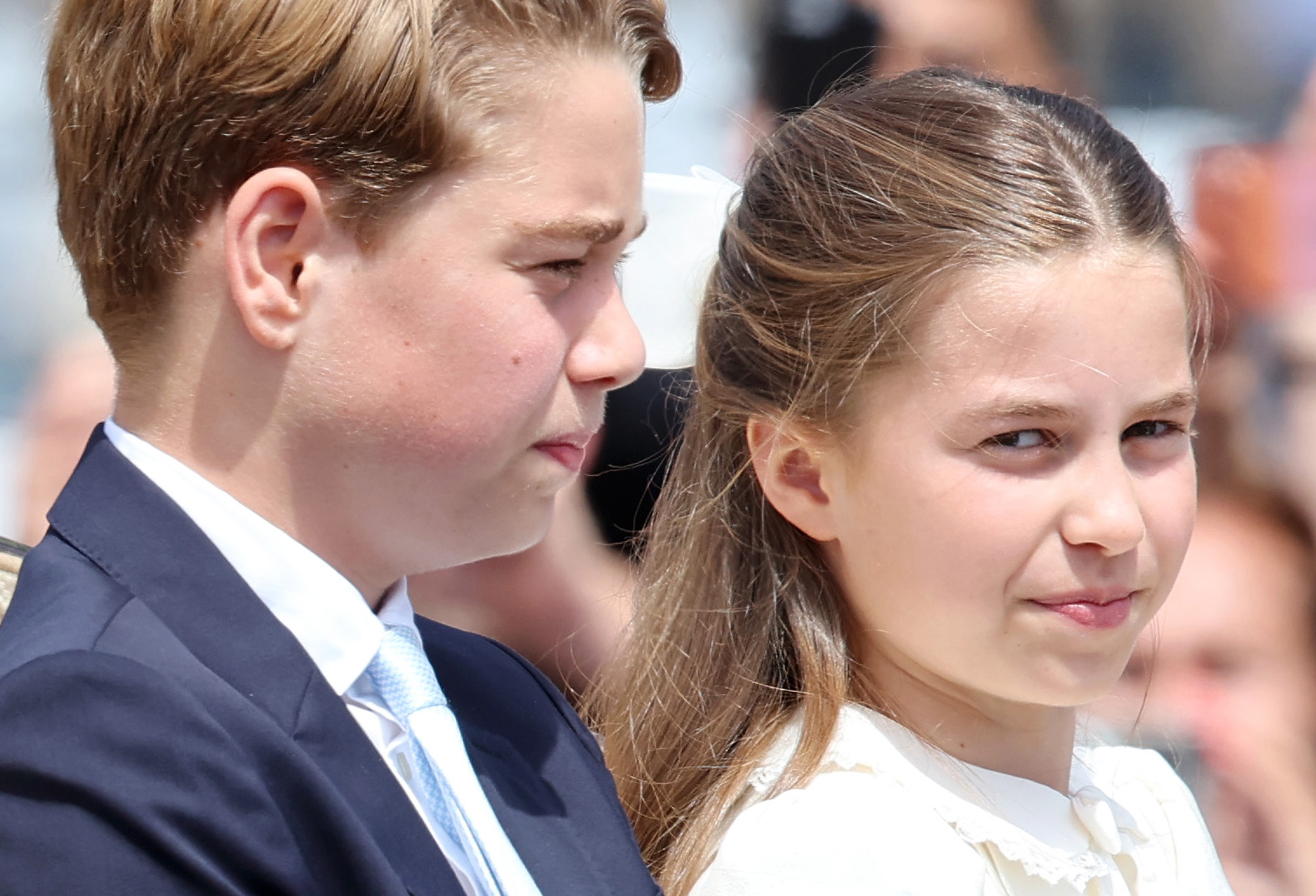 Princess Charlotte wearing a white dress with a matching bow in her long brown hair attending Trooping the Colour 2026 with the Royal Family