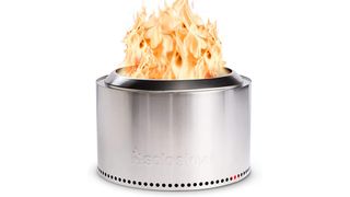 Stainless steel solo stove yukon shown on white background with fire coming out of the top.