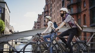 Germany, Hamburg, couple riding electric bicycles at Old Warehouse District
