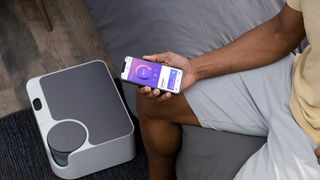 A person uses the Sleepme+ app with the Sleepme Dock Pro sleep system to control the temperature of their bed